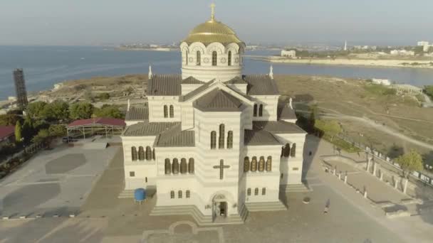 Gyönyörű templom, a tenger a háttérben. Lövés. Táj egy ortodox templomot és a tengerre. Minden ember számára nyilvános helyen — Stock videók