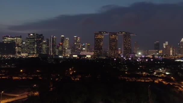 СИНГАПУР - 13 июня 2018 года: Воздушный вид на город Сингапур ночью, обзор залива Марина и финансовых районов. Выстрел. Ночной вид Сингапура на отель Marina Bay Sands — стоковое видео