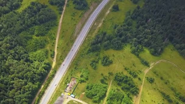 Vista aérea de carretera fangosa país. Clip. Vista aérea de los coches que conducen por carretera en el bosque — Vídeo de stock