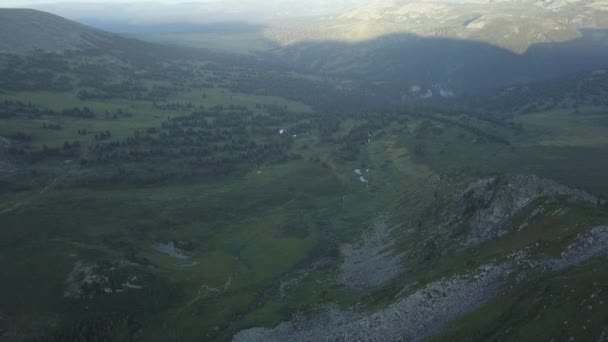 Fantastiskt flygning till den vackra dalen med skog i bergen. Klipp. Vacker grön dal omgiven av skogsklädda kullar och soliga bergssluttningarna täcks — Stockvideo