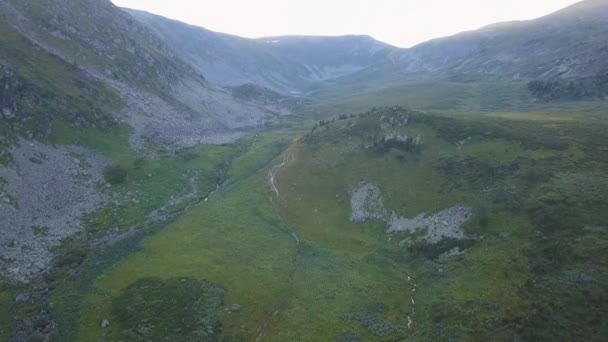 Weelderige mooie groene vallei en kliffen luchtfoto. Clip. Vliegen over steile heuvels richting de bergen — Stockvideo