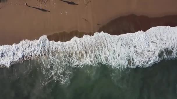 Vue aérienne de grandes vagues turquoise qui s'écrasent sur le bord de la mer et de personnes marchant sur un sable. Des actions. Beau paysage . — Video