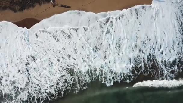 Vue aérienne de grandes vagues turquoise qui s'écrasent sur le bord de la mer et de personnes marchant sur un sable. Des actions. Beau paysage . — Video