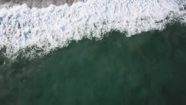Вид з повітря на великі бірюзові хвилі, що падають на берег моря, і люди, що йдуть на пісок. Запас. Красивий пейзаж . — стокове відео