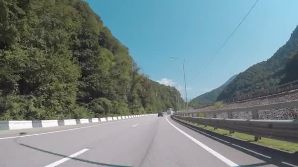 Belle vue depuis la voiture sur les montagnes du Caucase couvertes d'arbres et d'arbustes contre un ciel bleu clair par temps ensoleillé. Scène. Sotchi, Russie . — Video