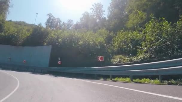 Vista desde el coche que se mueve por la carretera en las hermosas montañas cubiertas de árboles y arbustos bajo el teleférico. Escena. Regiones meridionales rusas . — Vídeo de stock