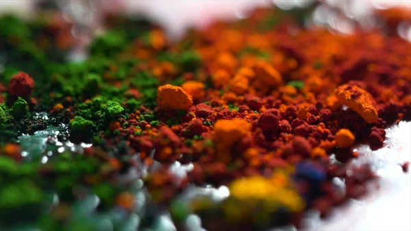 Κοντινό πλάνο της ξηρά μελάνια διαφορετικού χρώματος, τέχνη έννοια. Φωτεινά, ιριδίζοντα φόντο με πορτοκαλί, πράσινο και κίτρινο σε σκόνη. — Φωτογραφία Αρχείου