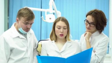 Başkanları, kötü haber ve tıp kavramı sallayarak doktorlar mavi klasör, tıbbi kayıtlarında arıyorsunuz. Kabine belgelerde bakarak beyaz laboratuar kat olarak üç genç stajyer.