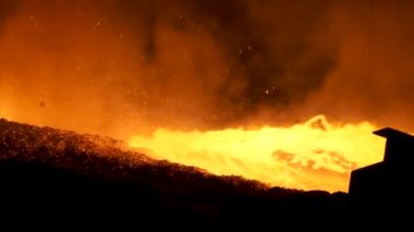 Yüksek fırın Metalurji tesisi, ağır sanayi kavramı üzerinden akan sıvı metal için kapatın. Birçok sparkles tarafa uçan ile bir borudan erimiş çelik dökme.