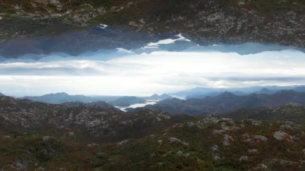 Aerial view of many high mountains and the river, mirror horizon effect. Beautiful landscape with rocks and the river on cloudy sky backgroun, inception theme. — Stock Video