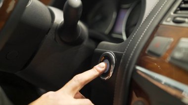 Yakın araba güç basarak adam parmak için Başlat, durdur düğmesi, ulaşım kavramı. Hisse senedi. Sürücü adam El arabasının motoru düğmeye.