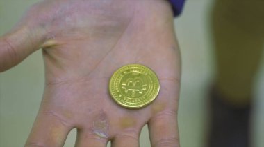 Bitcoin Hediyelik eşya madeni para üzerinde arka plan bulanık tutan adam el için kapatın. Hisse senedi. Yeni bir sanal para bir sembolü olarak bir elinde altın Bitcoin .