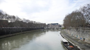 Güzel görünümü çok ağaç nehrin kıyısında büyüyen ile eski köprü ve yavaş akış ile bir nehir. Hisse senedi. Bir nehir, köprü ve kaldırım boyunca trafik sıkışıklığı sonbahar manzara.