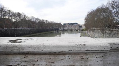 Güzel görünümü çok ağaç nehrin kıyısında büyüyen ile eski köprü ve yavaş akış ile bir nehir. Hisse senedi. Bir nehir, köprü ve kaldırım boyunca trafik sıkışıklığı sonbahar manzara.