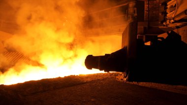 Birçok sparcles ve Buhar, ağır sanayi konsepti ile kepçe akan erimiş çelik. Modern çelik bitki ve erimiş metal Chute yakın.