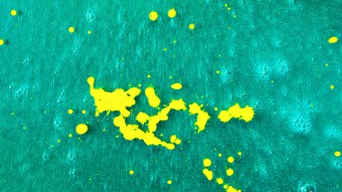 Üstten Görünüm sarı boya güzel turkuaz yüzeye, sanat kavramı düşen bırakır. Deniz mavisi yüzeye damlaması sıvı sarı mürekkepler.