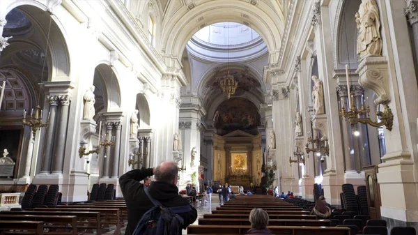 Superbe intérieur de la cathédrale en Italie avec beaucoup de gens à l'intérieur en regardant l'architecture et en prenant des photos, concept de religion. Des actions. Salle d'église légère avec des touristes marchant entre les bancs . — Photo