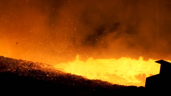 Primer plano para el metal líquido que fluye desde el alto horno en la planta metalúrgica, concepto de la industria pesada. Verter acero fundido de una tubería con muchos destellos volando hacia los lados . —  Fotos de Stock