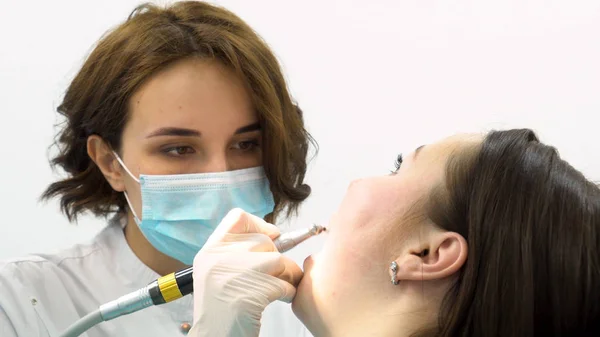 Close-up voor jonge tandarts vrouw het uitvoeren van Tandcariës preventie, geneeskunde concept. Vrouw op de tandarts stoel tijdens een tandheelkundige procedure in de kliniek. — Stockfoto