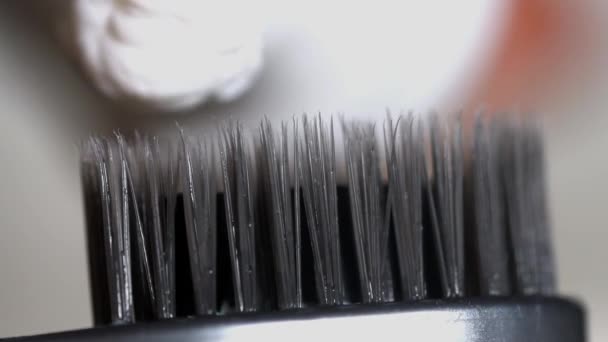 Pasta de dentes manchar em uma escova de dentes preta. Mídia. Pasta de dentes manchada na escova de dentes close-up — Vídeo de Stock