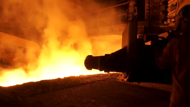 Lavoratore metallurgico in uniforme protettiva presso l'acciaieria che controlla il processo di colata dei metalli fusi a caldo. Uomo che lavora nell'industria pesante . — Video Stock