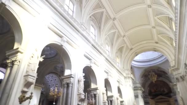 Dentro de una iglesia grande y hermosa con arcos y estatuas cerca de paredes de luz, concepto de religión. Acciones. Interior de la catedral con las estatuas de ángeles y santos, vista al techo y las paredes . — Vídeo de stock