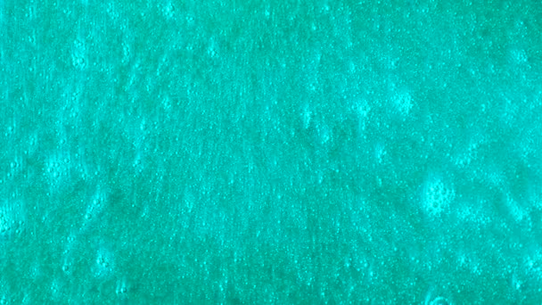 Bright turquoise background with bubbles moving slowly. Beautiful blue surface with shining particles flowing. — Stock Video