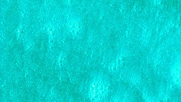 Fond turquoise brillant avec des bulles se déplaçant lentement. Belle surface bleue avec des particules brillantes qui coulent . — Video
