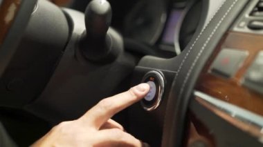 Yakın araba güç basarak adam parmak için Başlat, durdur düğmesi, ulaşım kavramı. Hisse senedi. Arabasının motoru düğmeye ve kontrol paneli ışıkları yakmaya sürücü adam el.