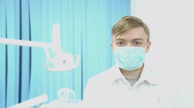 Maske ve tedavi odası arka plan üzerinde Beyaz önlük doktor. Medya. Çekici maskeli doktor hastayı tedavi başlatmak için hazır
