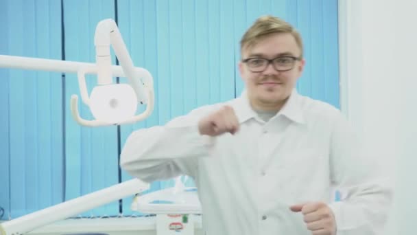 Doutor em casaco branco feliz e dançando. Mídia. Dentista de casaco branco e óculos dançando alegremente de excelente trabalho feito — Vídeo de Stock