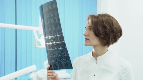 Doctora buscando resonancia magnética. Medios. Atractiva doctora mirando las radiografías La resonancia magnética sacude la cabeza frustrada — Vídeo de stock