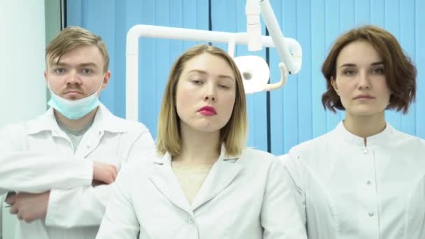 Equipa de médicos de pé com as mãos cruzadas. Mídia. Três médicos de uniforme branco estão de braços cruzados. — Vídeo de Stock