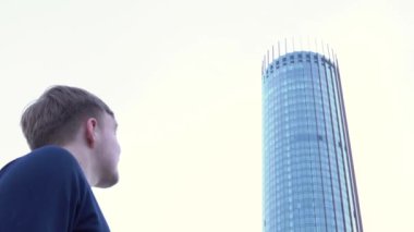 Dikiz man cam binasında arıyorum. Medya. Adam standları ve modern ofis binası cam cephe görünüyor