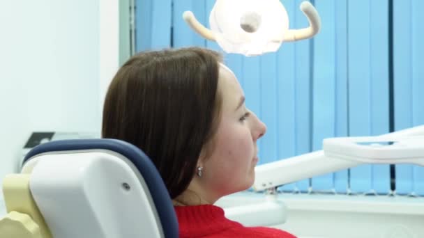 La dentista trabaja con la paciente. Medios. Mujer dentista examina y trata a los pacientes dientes con equipo dental profesional — Vídeo de stock