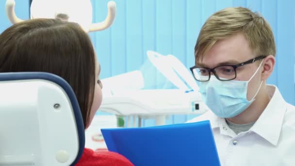 남자 치과 자에 환자를 참조합니다. 미디어입니다. 문서를 검사 하는 치과 의사는 치과 검사 하는 동안 환자와 상담 — 비디오