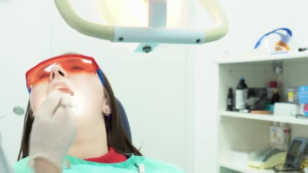 Profesionální nástroje zubař léčí zuby. Média. Pacient, ústa dokořán, sedí na židli u zubaře, který léčí zuby s profesionálními nástroji — Stock video