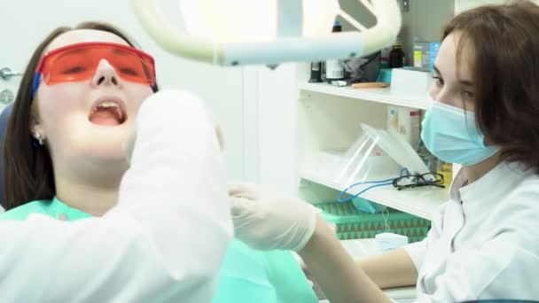 Βοηθός δίνει εργαλεία οδοντίατρο. Μέσα μαζικής ενημέρωσης. Βοηθός οδοντιάτρου παρέχει τα απαραίτητα εργαλεία για τη διάρκεια της θεραπείας των ασθενών δοντιών — Αρχείο Βίντεο