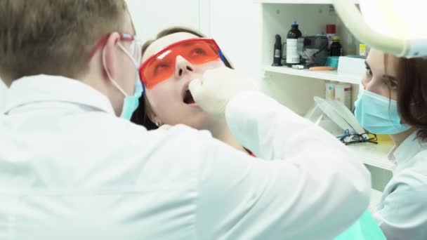 Assistente dà strumenti al dentista. I media. Assistente dentista fornisce gli strumenti necessari durante il trattamento dei denti pazienti — Video Stock