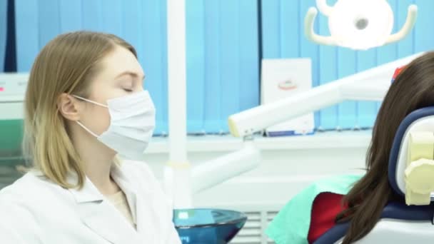 Dentiste et assistant de travail. Les médias. Assistant dentaire lui donne des outils pendant la procédure de traitement dentaire du patient — Video