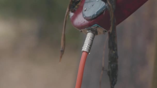 Zblízka pohled elektrická kytara pouzdro a kabel v kapky vody a řas. V UK. Hudba a příroda. — Stock video