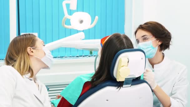 牙科诊所医牙小组近距离治疗年轻女性患者的牙齿。牙科保健. — 图库视频影像