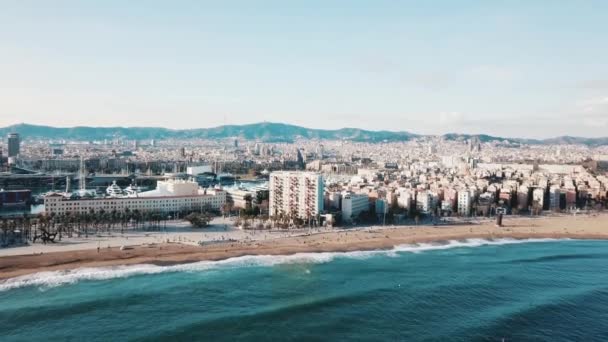 Aerial view of the beautiful coastal city, seashore and clear turquoise sea water against blue sky and mountains on the background. Stock. Resort season. — Stock Video