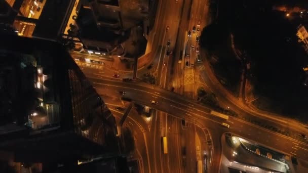 Vue aérienne de la ville la nuit avec des bâtiments modernes, carrefour autoroutier et voitures en mouvement. Des actions. Grande ville vie nocturne . — Video