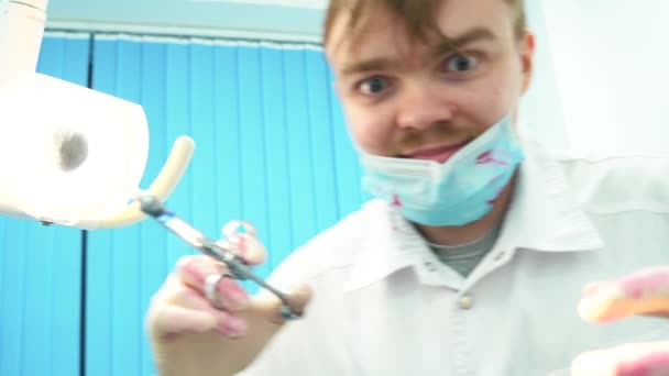 Close-up of crazy dentist at work with a protective mask stained with blood. Bloody psychopath. — Stock Video