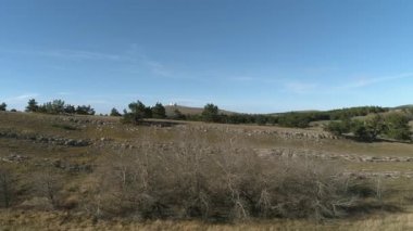 Mavi gökyüzü ve bulutlar karşı yeşil tepeler ile güzel iğne yapraklı ağaçlar. Vurdu. Fütüristik binaları ile bir tepede görüntülemek