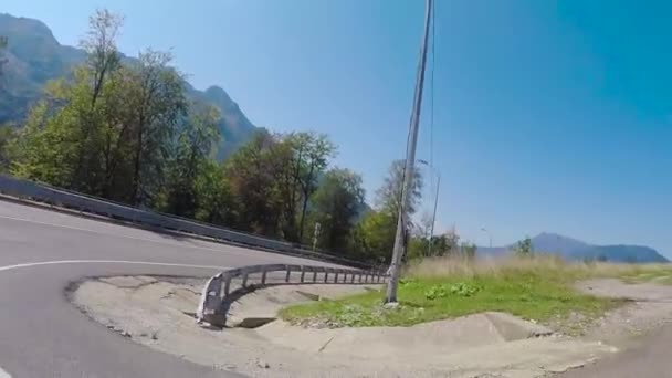 Autos, die auf einer Landstraße in sommerlicher Landschaft unterwegs sind. Szene. eine Autofahrt auf der sonnigen Straße. bergiges Gebiet — Stockvideo