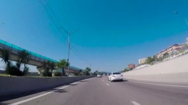 Sochi, Rusya Federasyonu - Haziran 2018: Şehrin güneyinde otobanda güneşli bir günde sürüş. Sahne. Yaz aylarında güney şehri