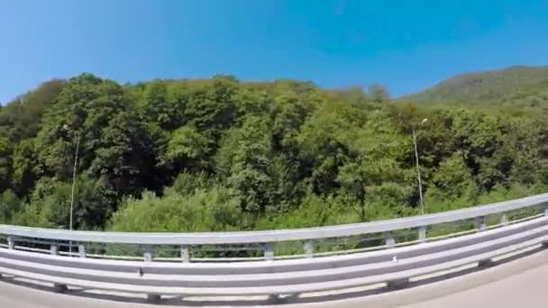 Auto in movimento su una strada statale nel paesaggio estivo. Scena. Un viaggio in auto sulla Sunny Road. Zona montuosa — Video Stock