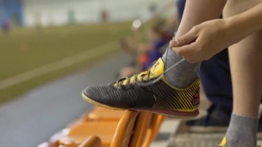 Genç futbol oyuncu ayakkabı bağı bağlıyor. Hisse senedi. Çocuk futbol ayakkabıları ayakkabı bağı bağlama